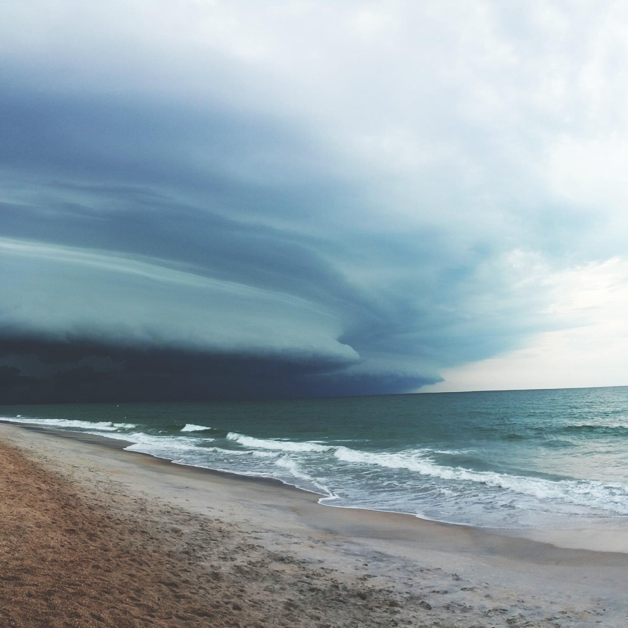 Stormy sky over a beach with dark clouds and ocean waves in Vilano, FL