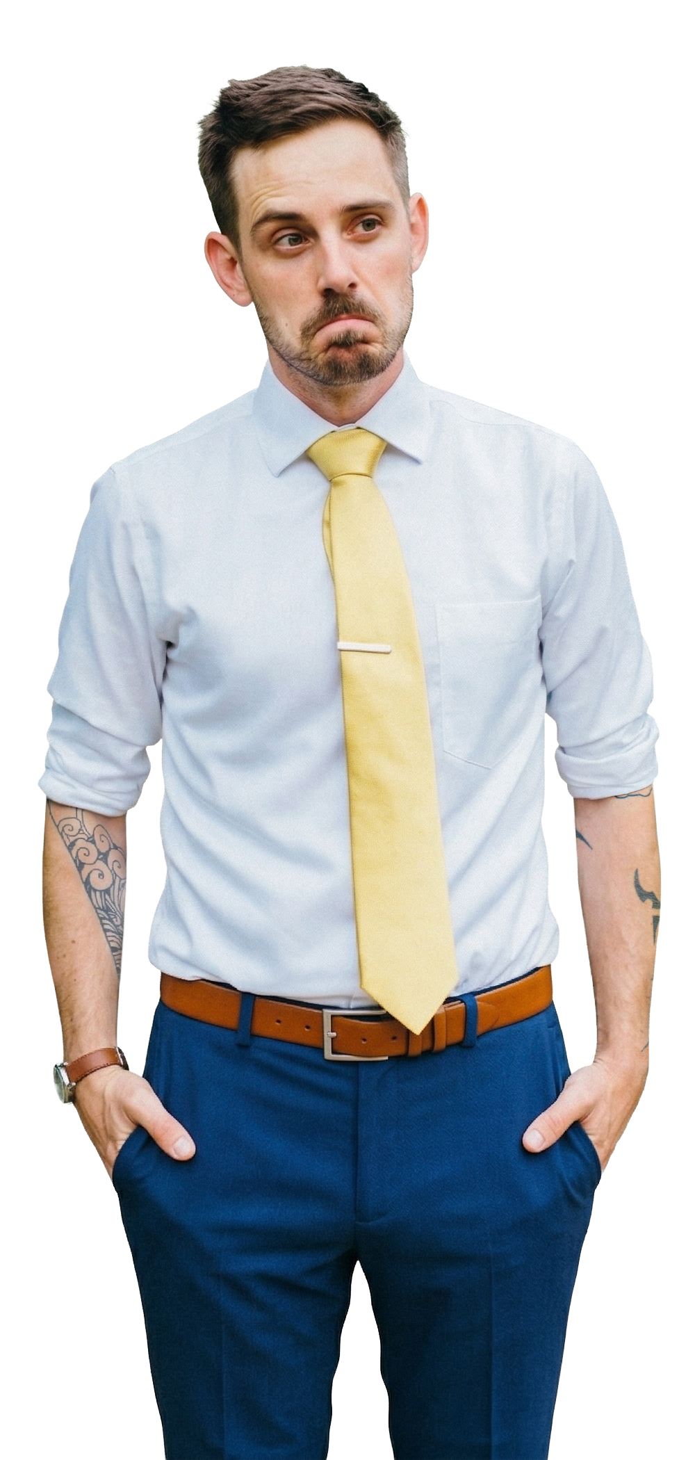 Photo of Brent White standing, wearing a white button-up shirt with rolled sleeves, a gold tie with a silver tie clip, a brown leather belt, and navy blue dress pants. His hands are in his pockets and he has a slight smirk, looking off to his right. Tattoos are visible on both forearms, and he's wearing a brown leather watch on his right wrist.
