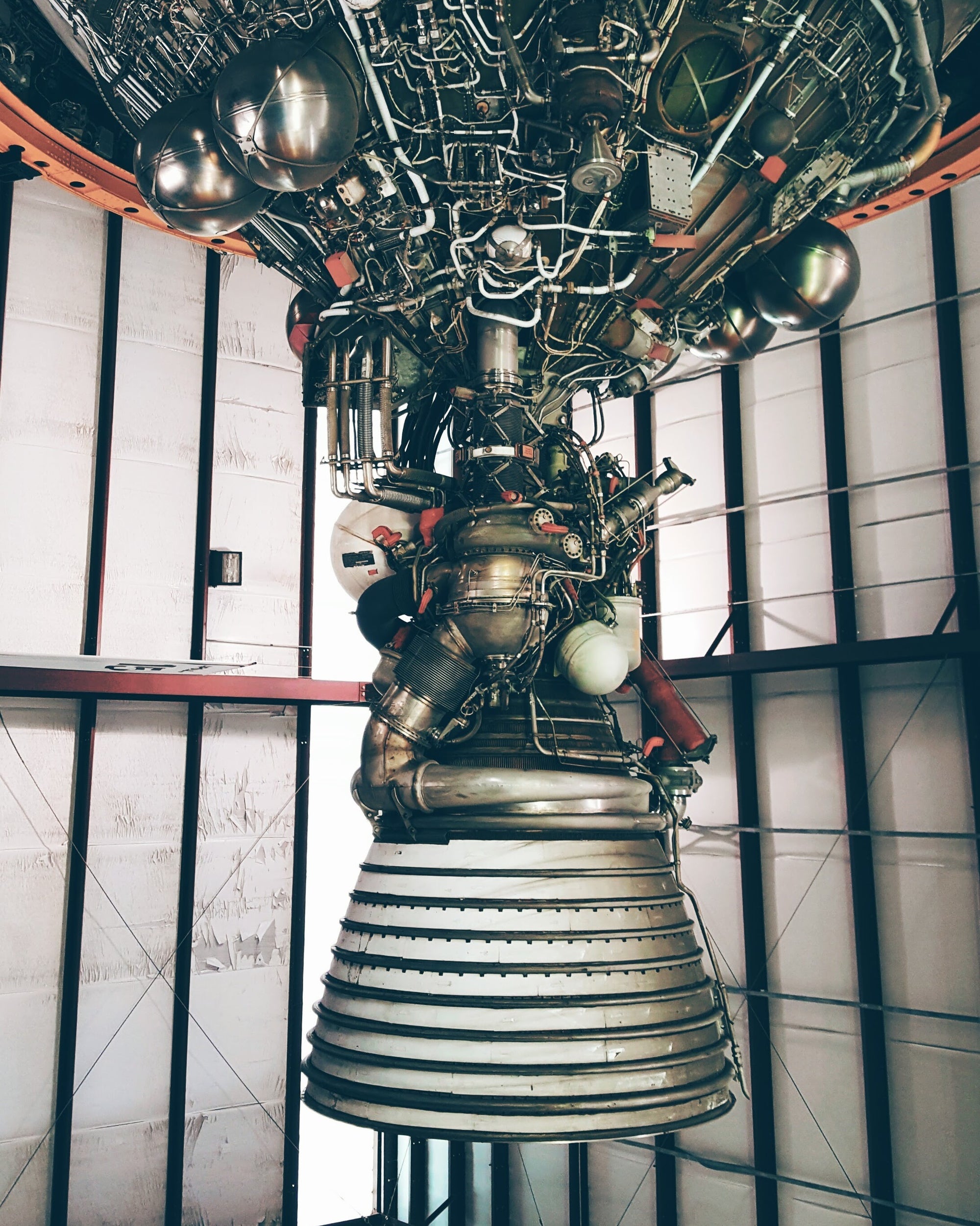 Large rocket engine mounted on a stand with a grid-like structure in the background at NASA in Texas