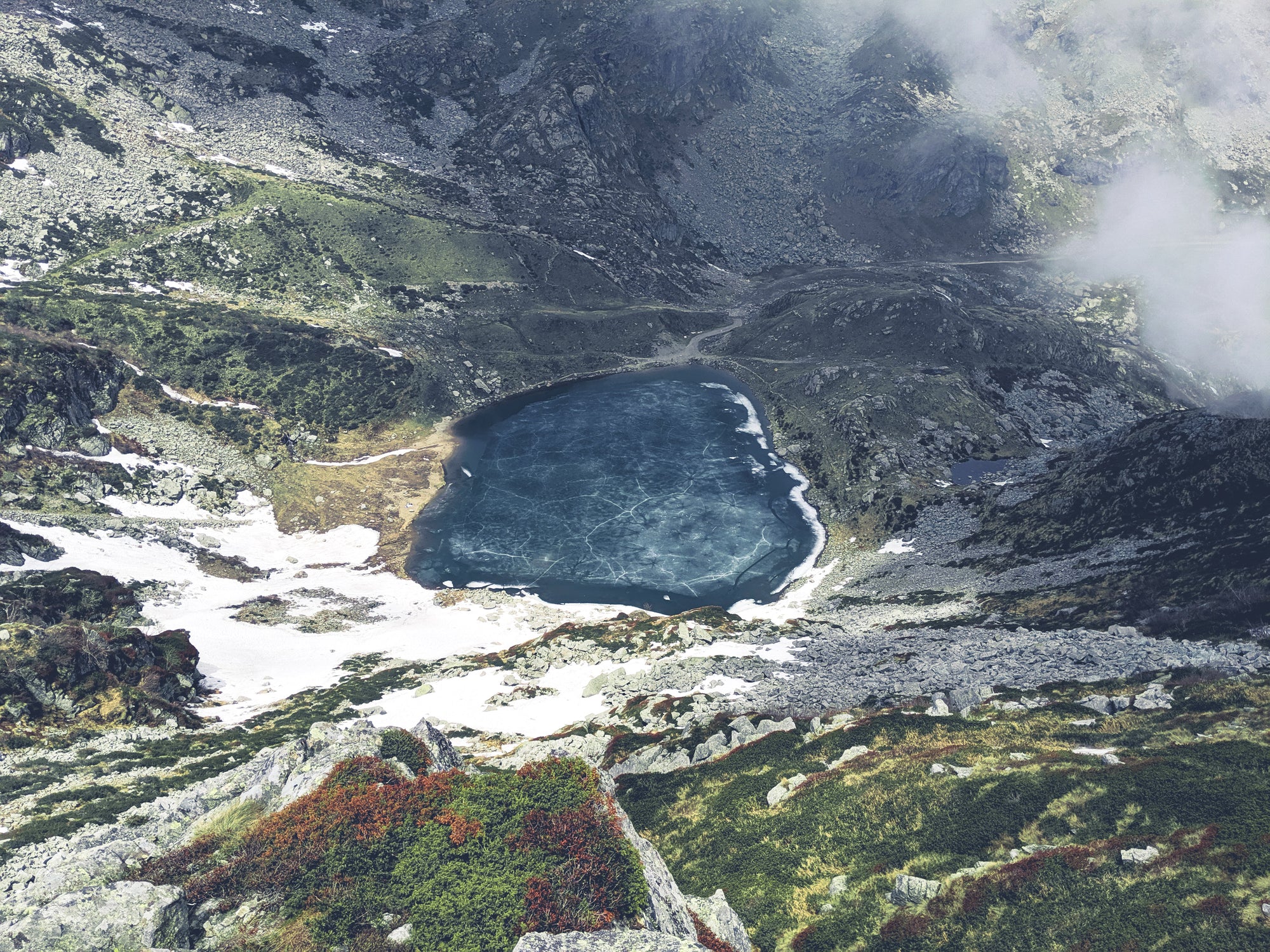 Mountain landscape with a lake surrounded by rocky terrain and vegetation in Lago del Mucrone, Italy