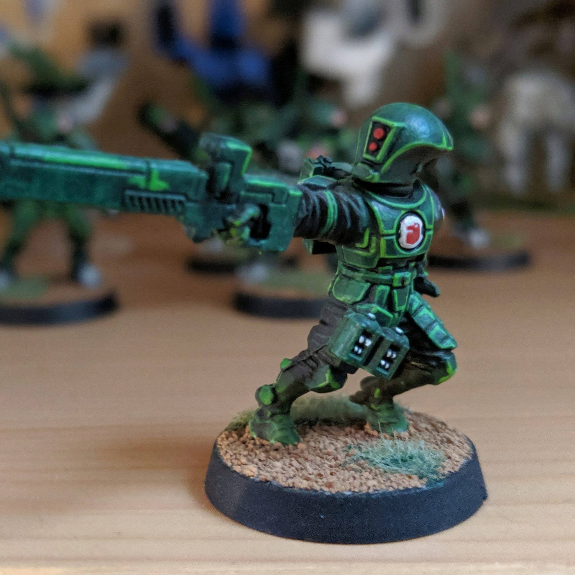 Tau Fire Warrior miniature from the Warhammer 40k, painted in a custom green and black "Black Ops" style color scheme.