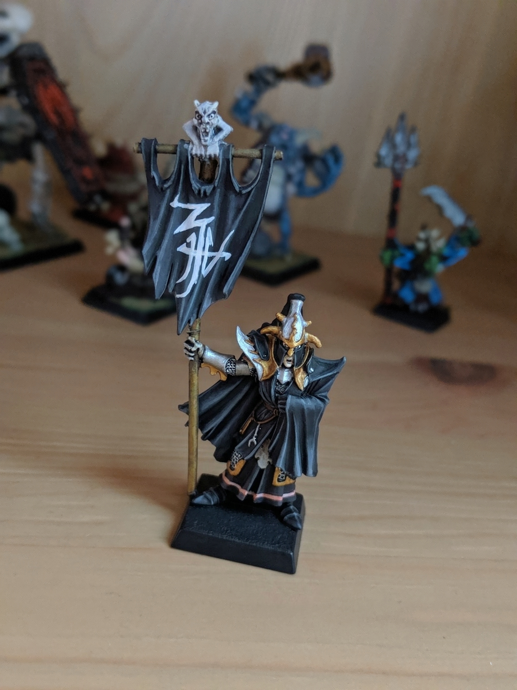 Warhammer Fantasy miniature of a Dark Elf Black Guard Command standard bearer, featuring a detailed painted banner. 