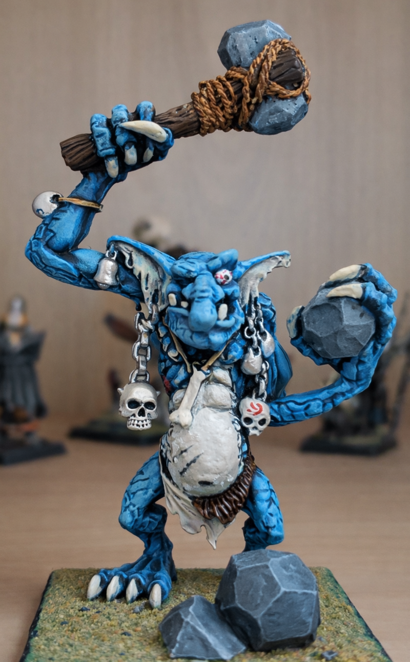 Warhammer Fantasy Stone Troll miniature, painted with blue skin and a  stone-like hide, wearing bells and chains. 
